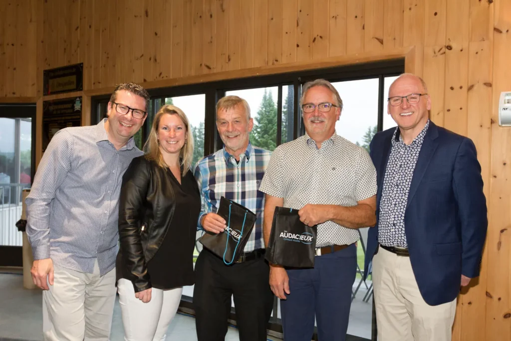 Cinq adultes posant avec sacs Les Audacieux