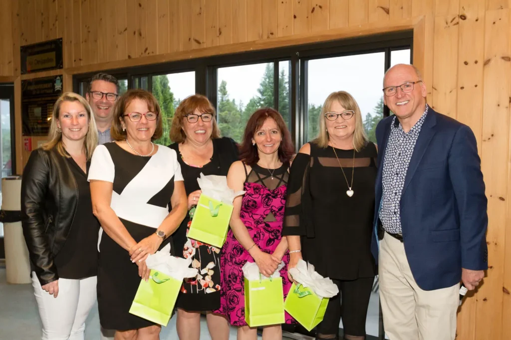 Groupe d’adultes souriants avec sacs cadeaux verts