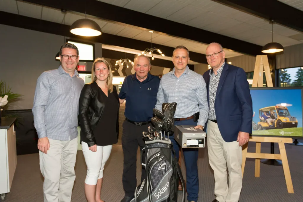 Cinq adultes posent avec sac de golf