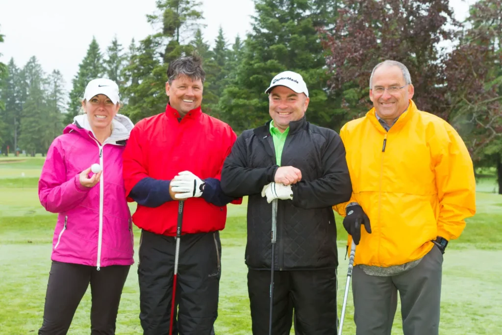Quatre golfeurs souriants sur un parcours verdoyant