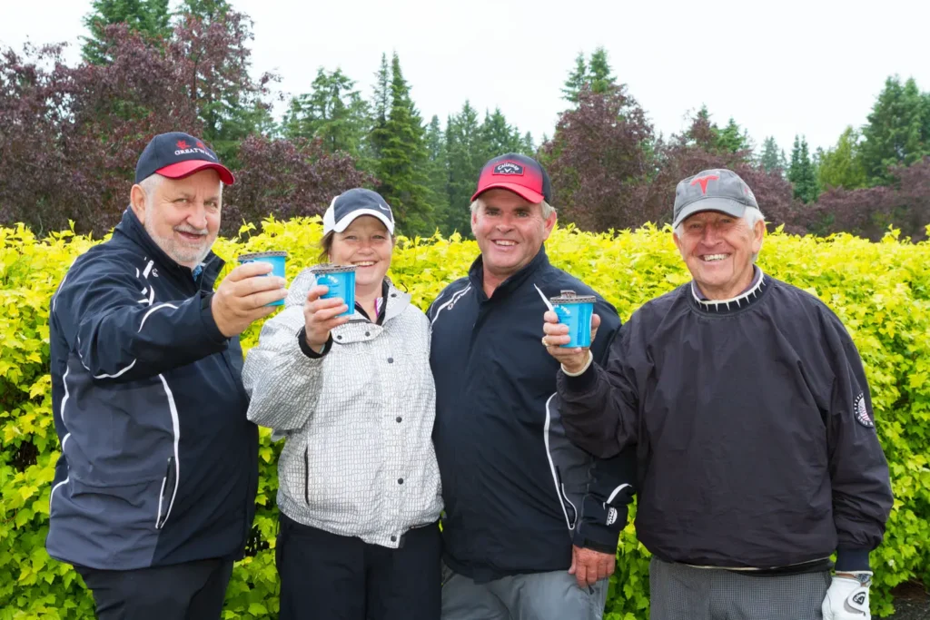 Quatre golfeurs trinquent en plein air