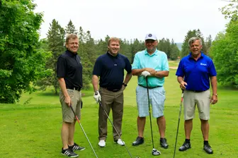 Quatre hommes sur un parcours de golf