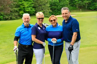 Quatre adultes souriants sur un parcours de golf