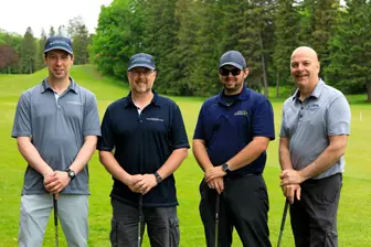 Quatre hommes avec clubs sur un golf