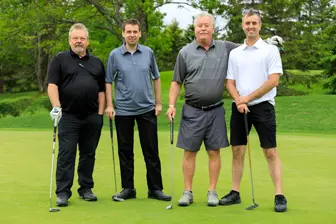 Quatre hommes sur un terrain de golf