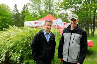 Deux hommes devant un stand en plein air