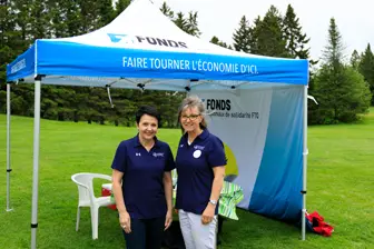 Deux femmes sous tente promotionnelle bleue