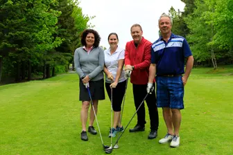 Quatre adultes sur un parcours de golf