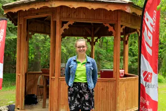 Femme devant kiosque en bois dans un parc