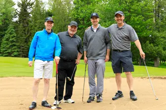 Quatre hommes avec clubs sur terrain de golf