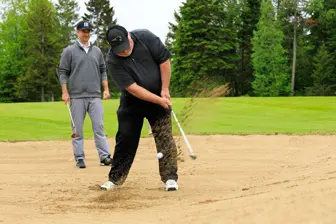 Golfeur frappant balle depuis bunker de sable