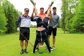 Golfeurs posant sur un green, un en équilibre
