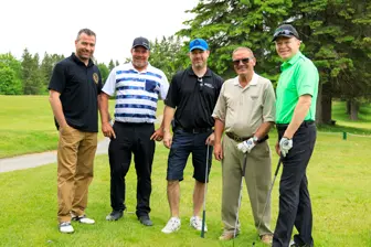 Cinq hommes sur un parcours de golf