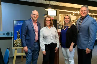 Quatre professionnels posant dans un showroom moderne