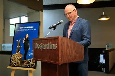 Homme au pupitre Desjardins lors d’un discours