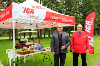 Deux hommes sous tente IGA en plein air