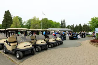 Voiturettes de golf alignées lors d’un événement extérieur