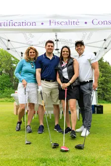 Quatre golfeurs posant sous une tente