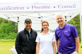 Trois personnes souriantes sous un stand extérieur