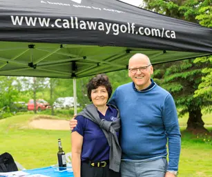Deux personnes souriantes sous tente Callaway Golf