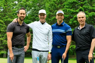 Quatre hommes avec clubs sur un golf