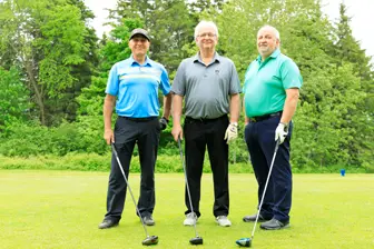 Trois hommes avec clubs sur un golf