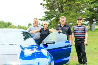 Quatre personnes près d’une voiture bleue