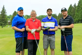 Quatre hommes avec clubs sur terrain de golf