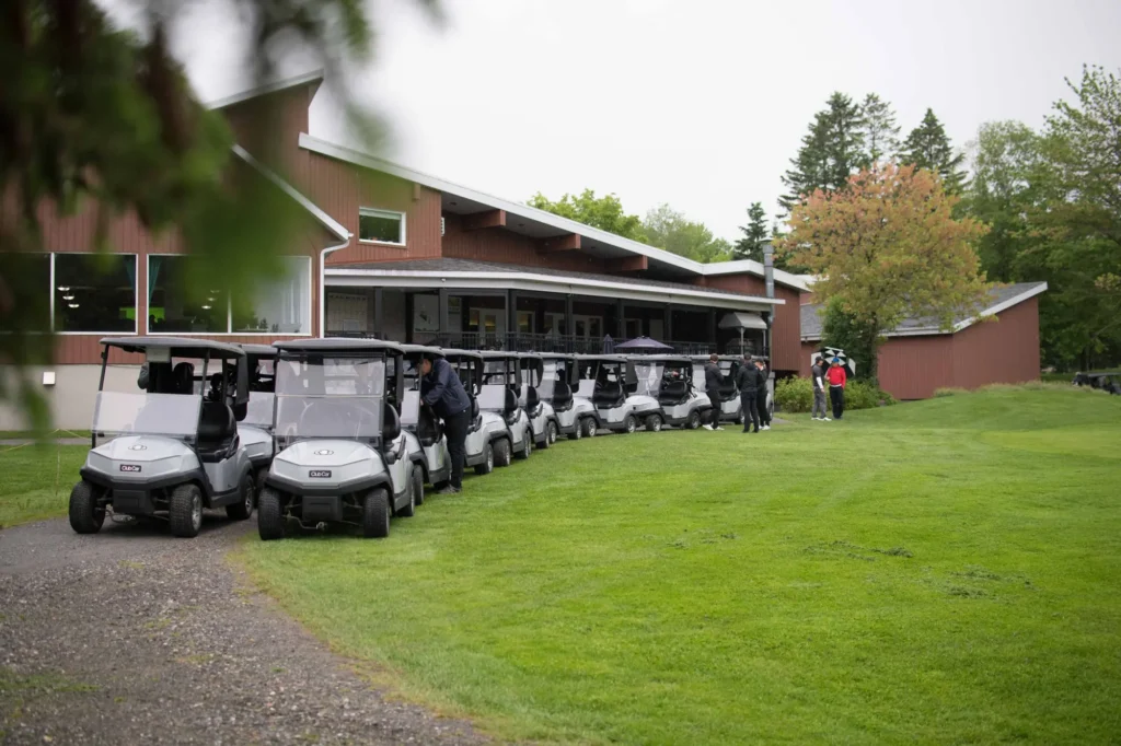 Voiturettes de golf alignées devant un clubhouse