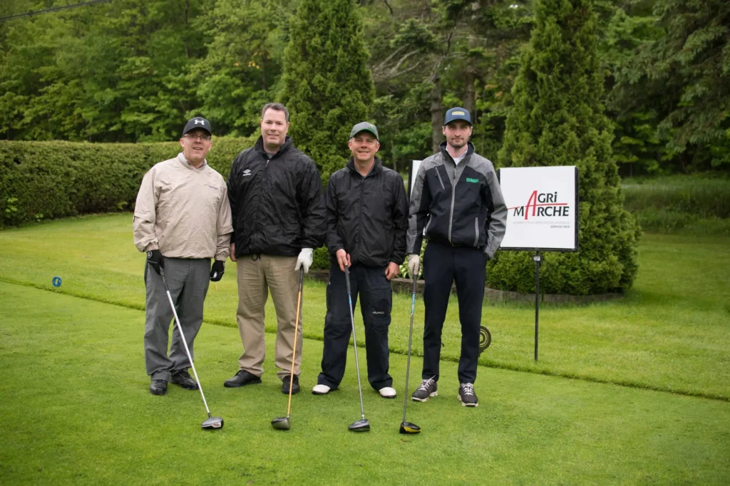 Quatre golfeurs posant sur un parcours verdoyant