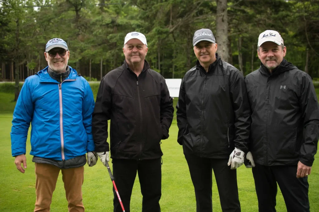 Quatre golfeurs posant sur un green