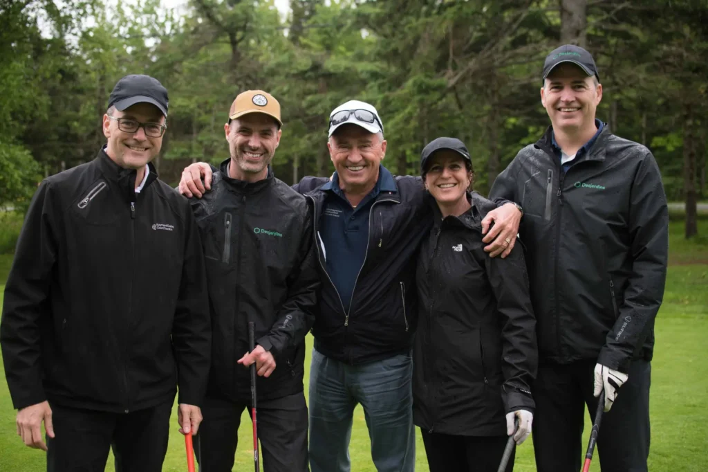 Cinq golfeurs souriants sur un parcours verdoyant