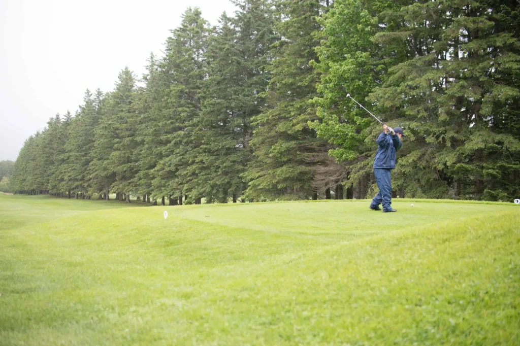 Golfeur frappant la balle sur un green