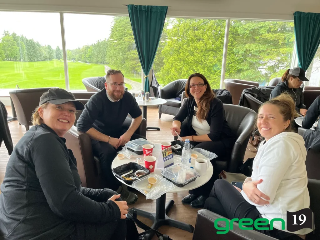 Quatre adultes déjeunent avec vue sur golf