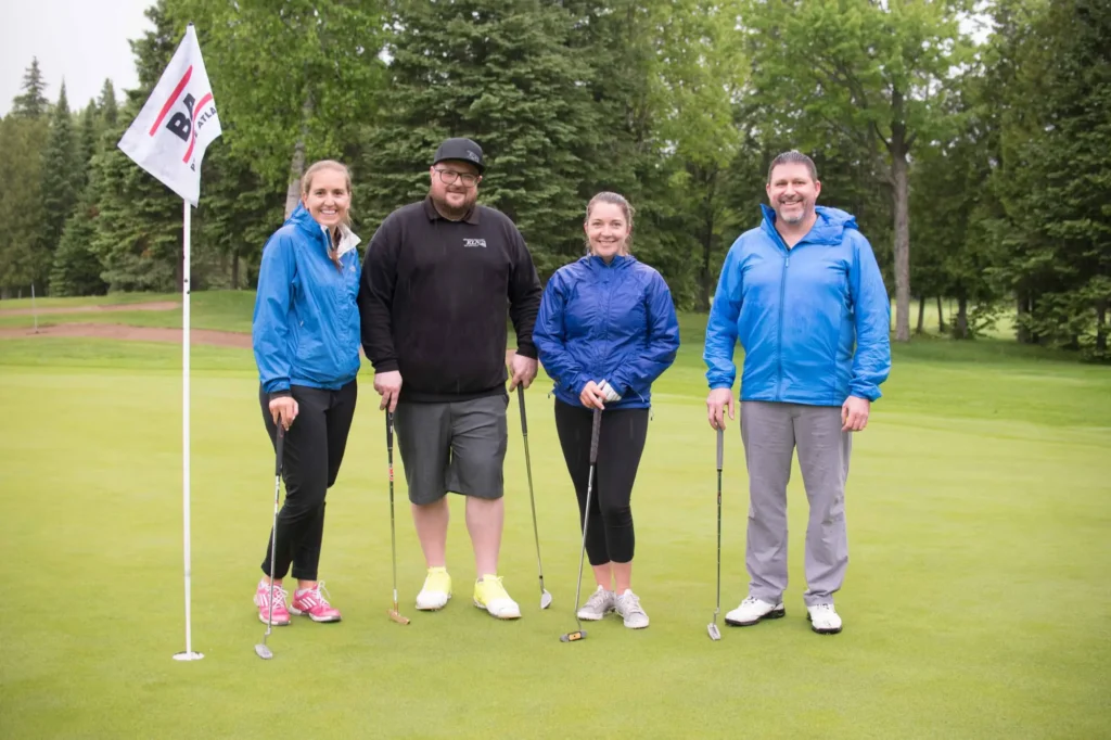 Quatre golfeurs souriants sur un green