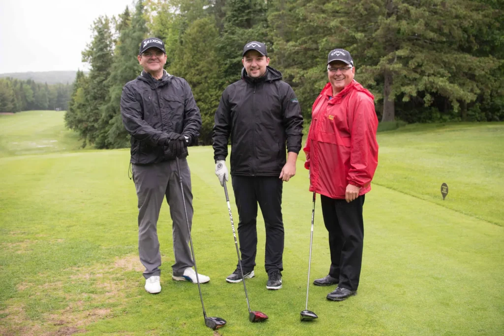 Trois golfeurs sur un parcours verdoyant