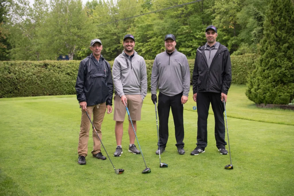 Quatre hommes avec clubs sur un parcours de golf