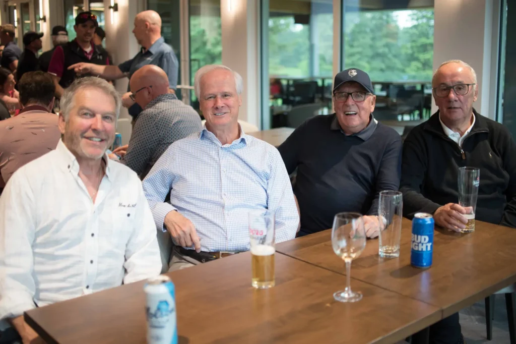 Quatre hommes attablés avec des boissons au bar