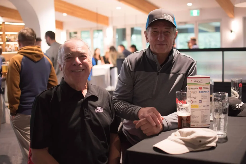 Deux hommes souriants à un événement de golf