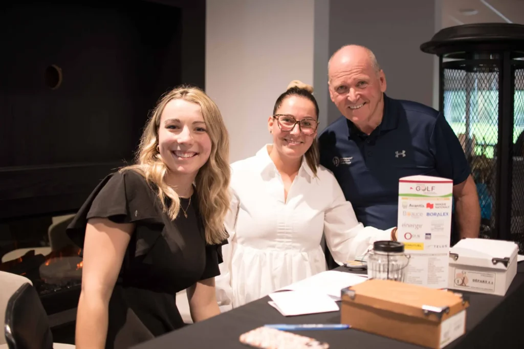 Trois personnes souriantes à un événement de golf