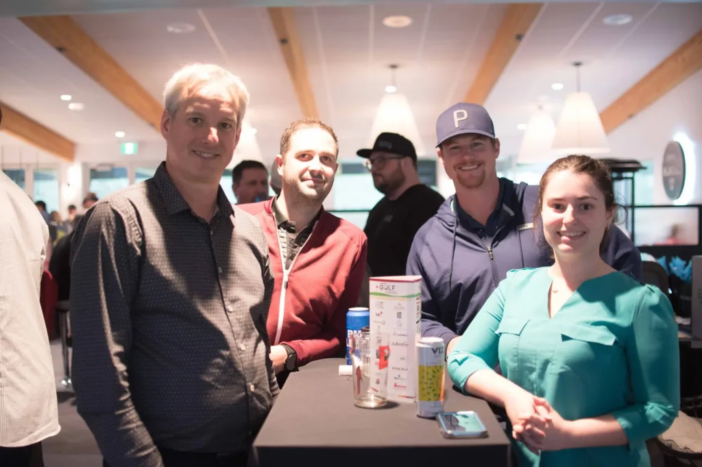 Quatre personnes souriantes autour d’une table haute