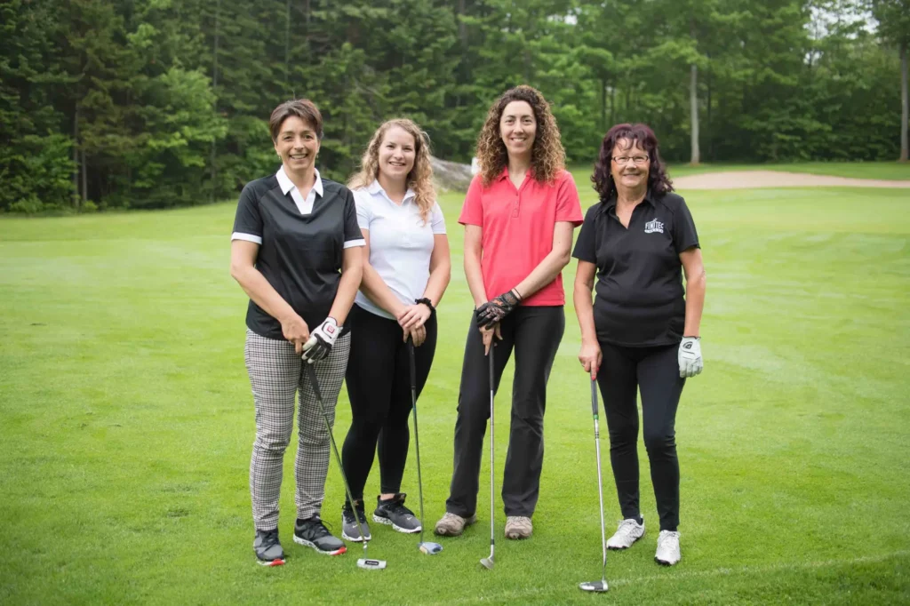 Quatre femmes souriantes sur un terrain de golf