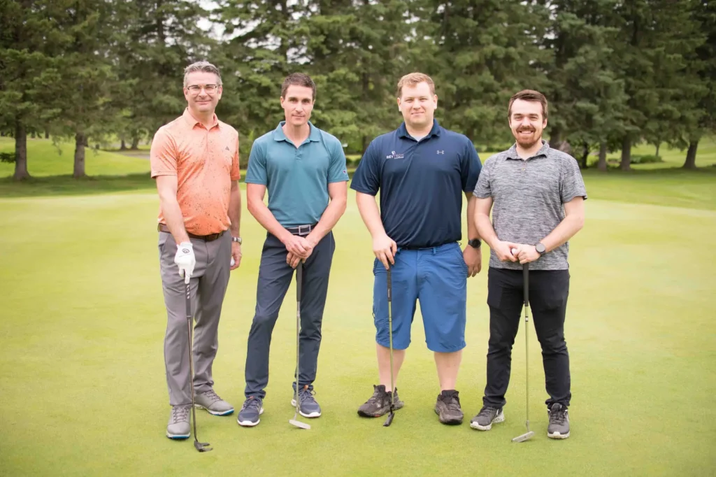 Quatre hommes sur un green de golf