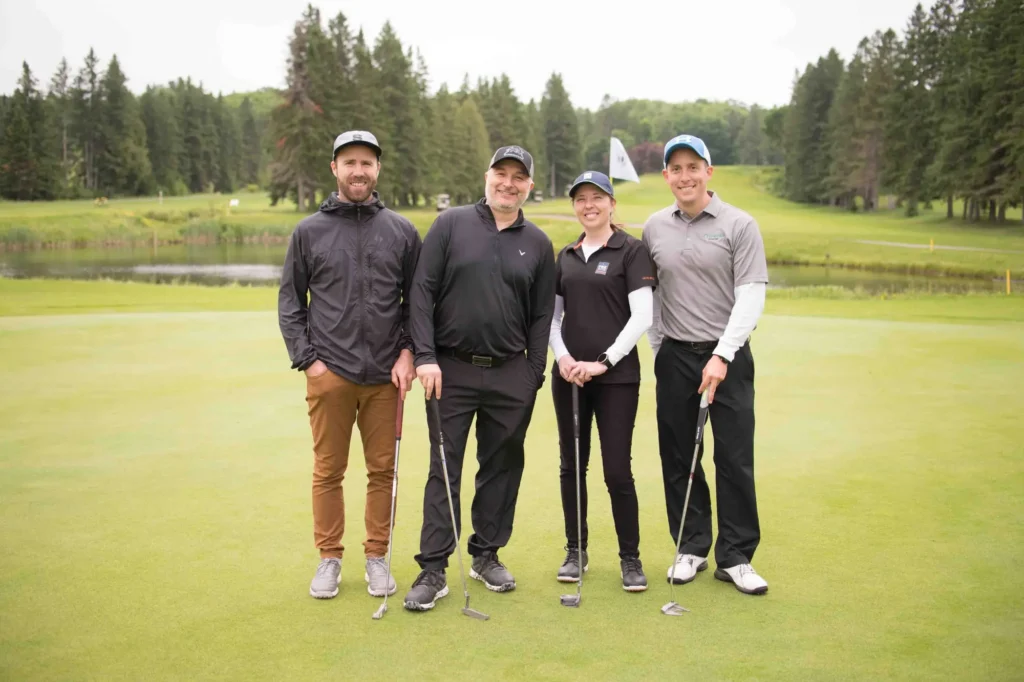Quatre golfeurs posant sur un green