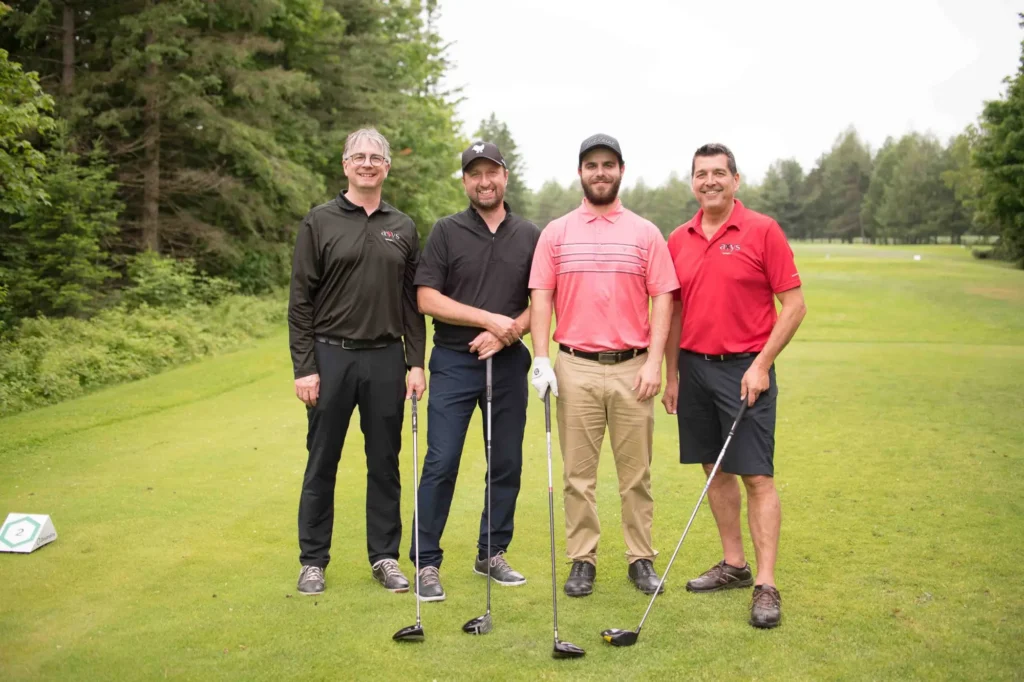 Quatre golfeurs posant sur un parcours verdoyant