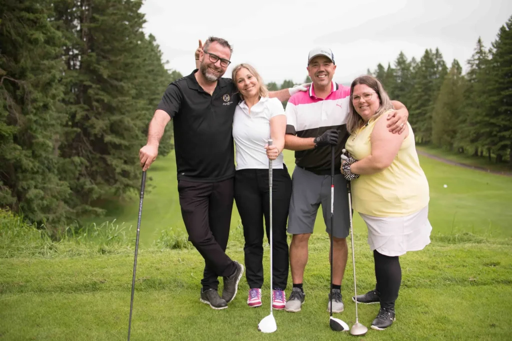 Quatre amis souriants sur un parcours de golf