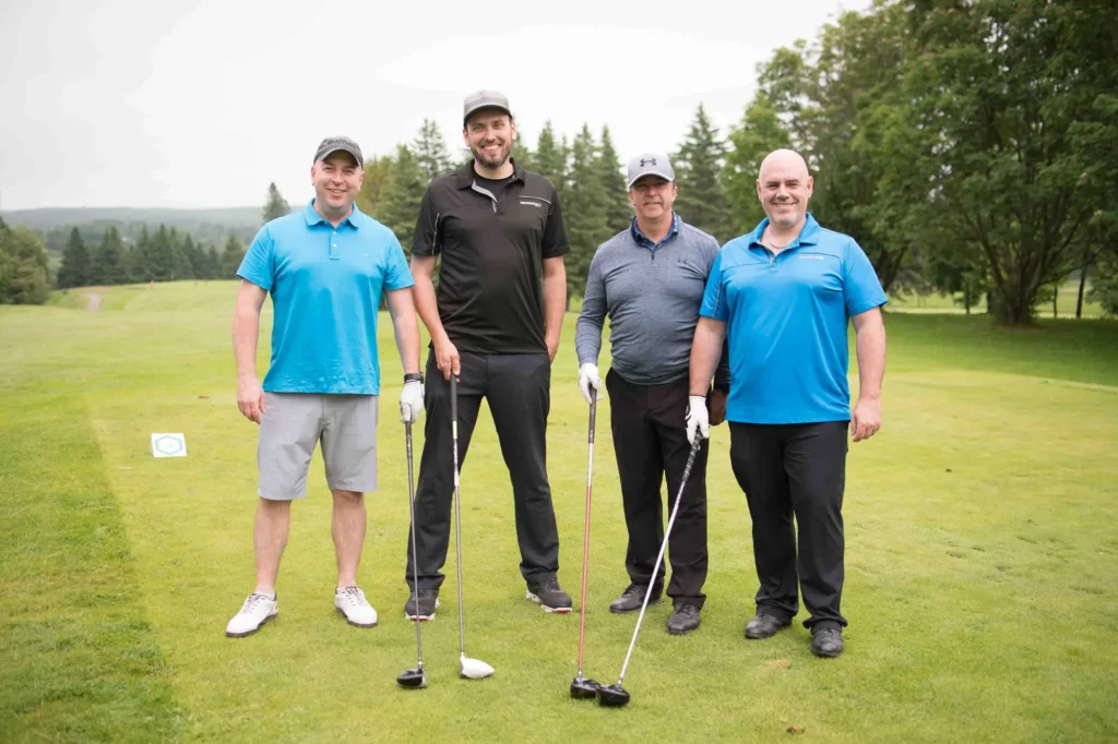 Quatre hommes avec clubs sur un parcours de golf
