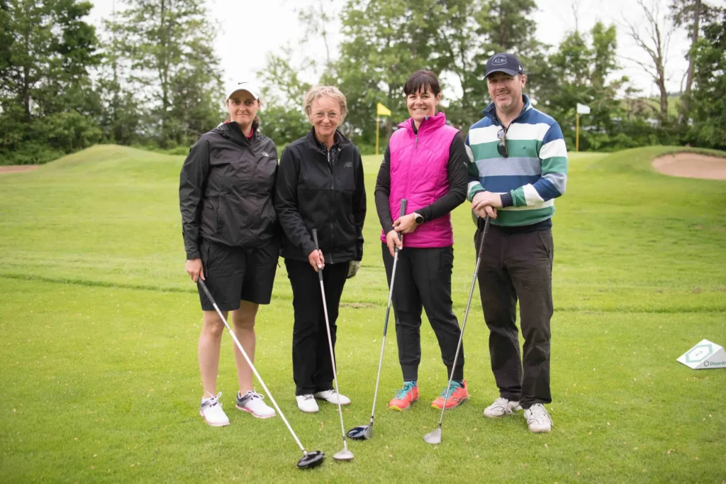 Quatre golfeurs posant sur un green