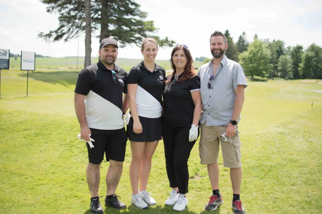 Quatre adultes posent sur un parcours de golf