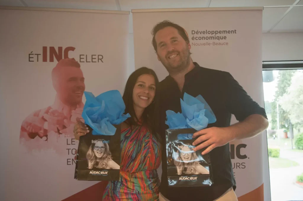 Deux personnes souriantes avec sacs cadeaux événement